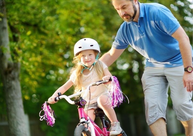 Father helping daughter on pushbike