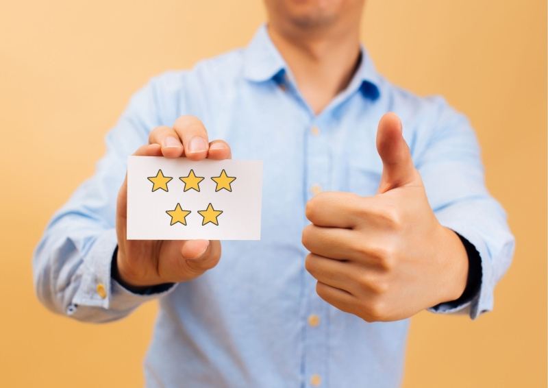 Person Holding a piece of paper with 5 stars on it.