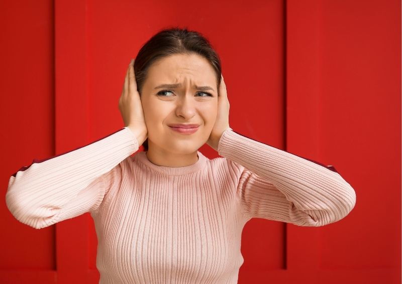 Woman covering her ears